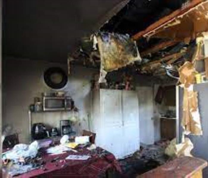 Kitchen fire started by burnt food effecting ceiling, walls, and furniture